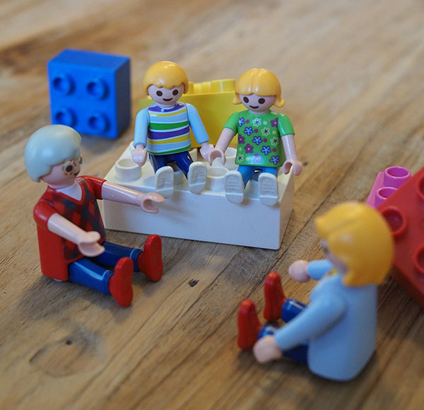 Psychotherapie - Playmobilfiguren auf Legosteinen